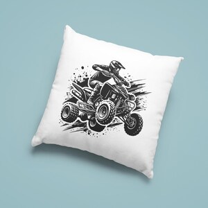 May include: Black and white illustration of a person riding an ATV on a dirt track. The ATV is in motion and the person is leaning into the turn. The image is on a white pillow.