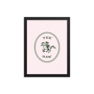 May include: A framed print with a pink background and a green circle containing a cowboy riding a horse. The circle has the text "YEE HAW" inside.