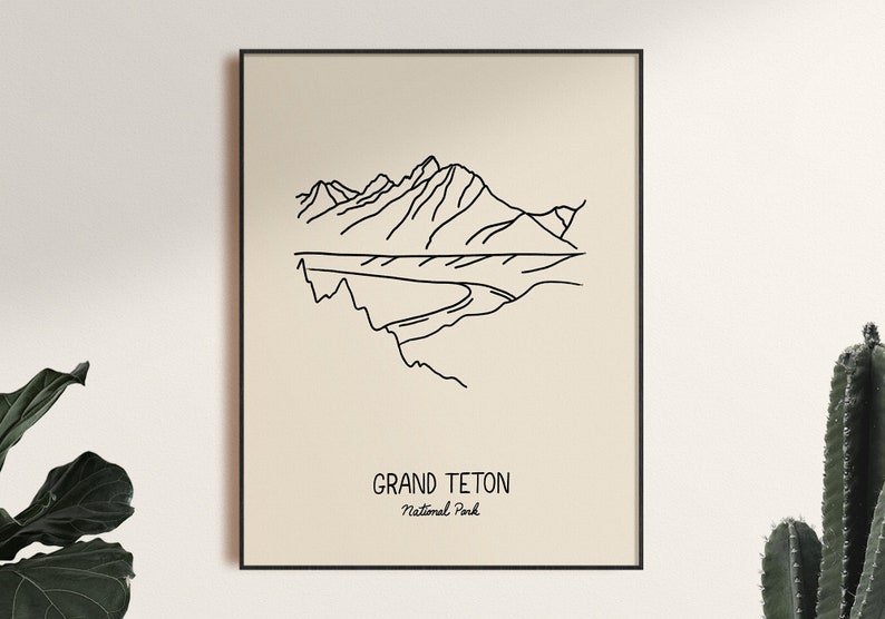 May include: A black and white line art print of the Grand Teton National Park mountains. The print has a beige background and is framed in black.