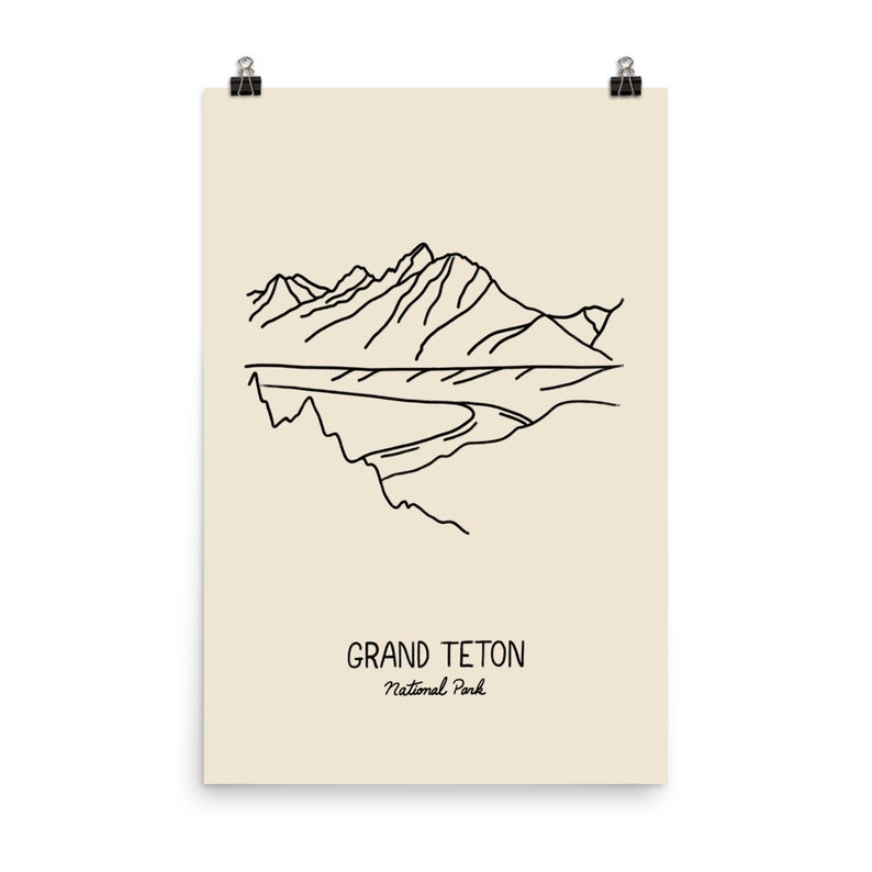 May include: A line drawing illustration of the Grand Teton National Park in Wyoming. The illustration shows a mountain range with a river flowing through it. The text "Grand Teton National Park" is written below the illustration.