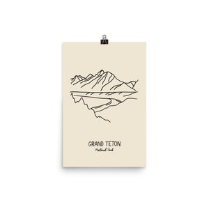 May include: A line drawing of the Grand Teton mountain range in black on a cream background. The text "Grand Teton National Park" is below the drawing.