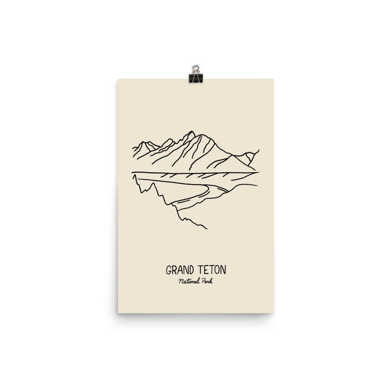 May include: A line drawing of the Grand Teton mountain range in black on a cream background. The text "Grand Teton National Park" is below the drawing.