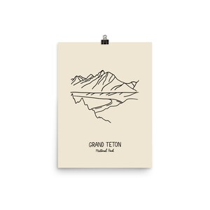 May include: Line art illustration of the Grand Teton National Park in Wyoming. The image features a mountain range with a river flowing through it. The text "Grand Teton National Park" is printed below the image.