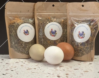 May include: Three clear pouches filled with dried herbs and flowers, each with a round label featuring a rooster and the text "www.faithandfarms.com". Three eggs in varying shades of white and brown are in front of the pouches.
