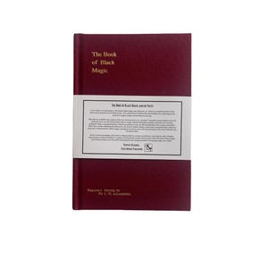 May include: A burgundy hardback book titled "The Book of Black Magic." The book features a white band with text, including "The Book of Black Magic and of Pacts." The bottom of the book reads "Privately Printed by Dr. L. W. deLaurence."