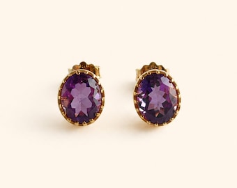 Peut inclure: Une paire de boucles d'oreilles à clous avec des améthystes ovales serties dans de l'or jaune. Chaque pierre précieuse violette présente une taille à facettes et est fixée par un sertissage en or festonné. Les boucles incluent des tiges.