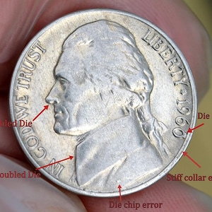 May include: A silver 1960 Jefferson nickel coin with visible errors. The coin features a profile of Thomas Jefferson and the words "IN GOD WE TRUST" and "LIBERTY 1960". Arrows point to "Doubled Die", "Die chip", and "Stiff collar error".