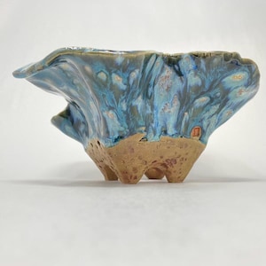 May include: A set of three ceramic mugs with a speckled, matte finish. The mugs are in shades of cream, light gray, and dark gray. Each mug has a simple, minimalist design, perfect for coffee or tea.