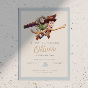 May include: A birthday invitation card with a light blue border, featuring Woody and Buzz Lightyear from Toy Story. The text says "To Infinity and Beyond" and "Oliver is turning two". Includes date, time, and location details.