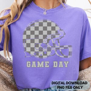 May include: A purple t-shirt featuring a gray and white checkered football helmet design. The words "GAME DAY" are printed in gray below the helmet. The shirt is a digital download, PNG file only.