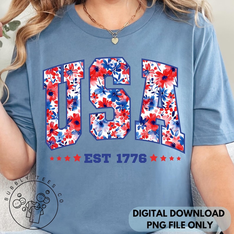 May include: A light blue t-shirt with the word "USA" in a floral pattern of red and blue flowers. Below the word "USA" is the text "EST 1776" with red stars. The shirt is a digital download.