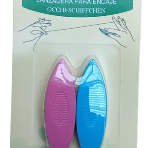 Op de afbeelding: Twee plastic tatting shuttles, &eacute;&eacute;n roze en &eacute;&eacute;n blauw, verpakt op een witte kaart met groene klaverontwerpen. De kaart vermeldt "Clover Tatting Shuttle" en "Art No. 479".