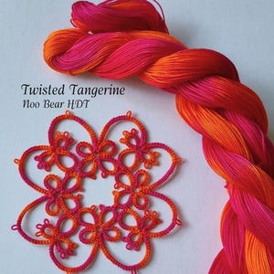 May include: A close-up of a skein of Twisted Tangerine colored thread and a completed tatting doily. The thread is a gradient of orange and pink. The doily is a flower shape in matching colors.