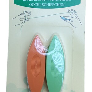 Op de afbeelding: Twee plastic tatting shuttles, &eacute;&eacute;n oranje en &eacute;&eacute;n groen, verpakt op een witte en groene achtergrond. De verpakking bevat de tekst "Clover Tatting Shuttle" en "Art No. 479".