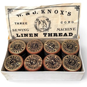 May include: An open box of W. & J. Knox's Linen Thread, featuring eight spools. The spools have gold and black labels. The box is labelled with the text "THREE SEWING LINEN THREAD". The box is vintage.
