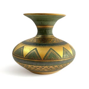 May include: A decorative ceramic vase with a bulbous body and a flared neck. The vase features a gold and green color scheme with geometric patterns. The gold sections are accented with triangular and linear designs, while the neck is a solid green.