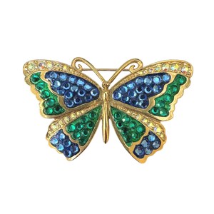 May include: A gold butterfly brooch with blue and green rhinestones.
