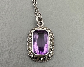 Può includere: Una collana con ciondolo in argento con una pietra ametista viola incastonata in una cornice di marcasite.