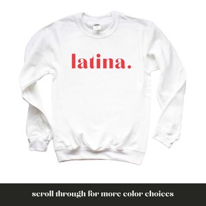 Op de afbeelding: Witte trui met het woord "latina" in rood op de voorkant.