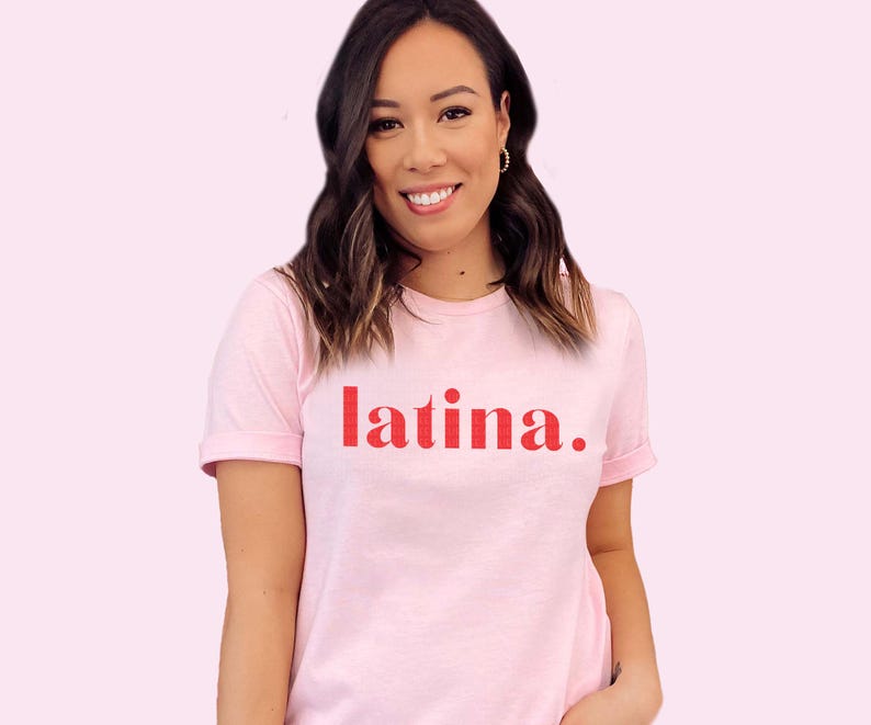 May include: A pink t-shirt with the word "latina" printed in red on the front.
