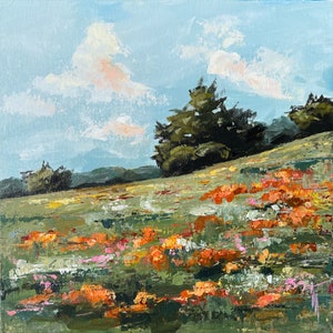 May include: A painting of a landscape with a field of orange, pink, and white flowers in the foreground.  The field is on a hillside with a group of dark green trees at the top of the hill.  The sky is blue with white clouds.