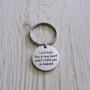 May include: Silver keychain with a round tag that reads "I will hold you in my heart until I hold you in heaven".