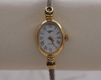 Delicado reloj de pulsera ovalado de dos tonos con alambre para mujer