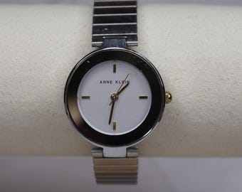 Elegante reloj bicolor Expansion para mujer: brillo cristalino y correa elástica atemporal.
