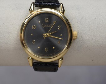 Reloj Cyrano gris cromado: correa de piel de serpiente negra con detalles dorados brillantes.