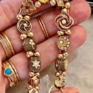 Armband med glidande berlocker i massivt guld med ädelstenar, opal, rubin, pärla och unika glidande berlocker