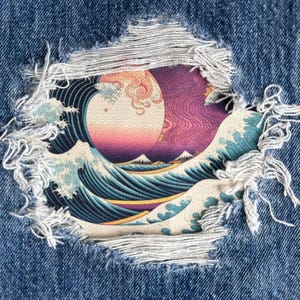 May include: Close-up of distressed denim with a tear revealing a vibrant Japanese wave print. The artwork features a large sun, mountains, and stylized waves in shades of blue, pink, and purple. The denim is a classic blue.