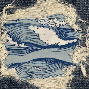 Könnte beinhalten: Nahaufnahme einer zerrissenen blauen Jeans mit einem eingenähten blauen und weißen Stoff-Patch. Der Patch zeigt ein Wellenmuster.