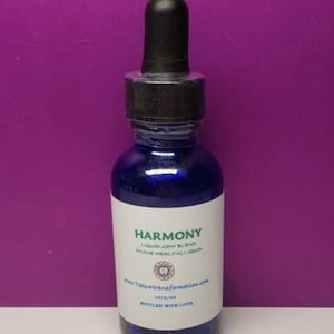 K&ouml;nnte beinhalten: Eine dunkelblaue Glasflasche mit einem schwarzen Tropfaufsatz. Die Flasche hat ein wei&szlig;es Etikett mit dem Wort "Harmony" und anderem Text. Der Hintergrund ist einfarbig lila.