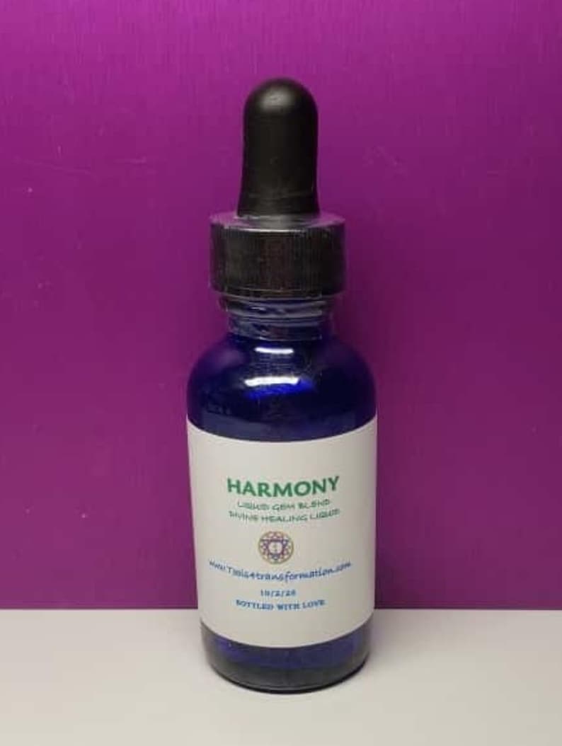 K&ouml;nnte beinhalten: Eine dunkelblaue Glasflasche mit einem schwarzen Tropfaufsatz. Die Flasche hat ein wei&szlig;es Etikett mit dem Wort "Harmony" und anderem Text. Der Hintergrund ist einfarbig lila.