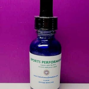 Op de afbeelding: Een kobaltblauwe glazen fles met een zwarte druppelaar. Het etiket luidt "SPORTS PERFORMANCE" en "LIQUID GEM BLEND DIVINE HEALING LIQUID". De fles bevat ook het websiteadres, de datum en de zin "BOTTLED WITH LOVE".