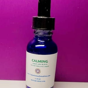 May include: A cobalt blue glass bottle with a black dropper. The label reads "CALMING" and "LIQUID GEM BLEND DIVINE HEALING LIQUID". The bottle contains a clear liquid. The label also includes a website address and the words "BOTTLED WITH LOVE".