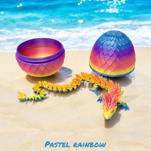 May include: A pastel rainbow dragon toy with a segmented body, a head with a spiky crest, and two egg-shaped containers. The containers are purple and blue with a rainbow pattern.