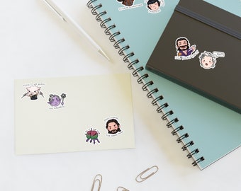 May include: A set of stickers featuring various characters and phrases. The stickers are on a white background with a notebook and pen in the background. The stickers include a character with a crown and the text "Cool & Aloof Princess", a character with horns and the text "Eternal & Smoothing", a character with a beard and the text "The Fuckers End Up In Jail", a character with a beard and the text "Stop Licking The Damn Thing", a character with a beard and the text "...Shit", a character with a crown and the text "Fuck It We Shall", a character with a crown and the text "No Brackets", and a character with a crown and the text "Do It For You".