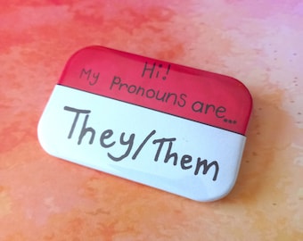Hola, mis pronombres son: elle/elles, LGBT+, insignia rectangular con el lema "Orgullo".