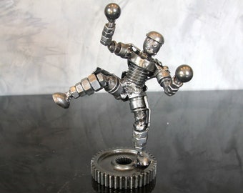 Escultura de robot malabarista de chatarra, figura de artista en pose de acción de acero soldado, estatua de droide de tuerca y perno de metal reciclado, decoración industrial