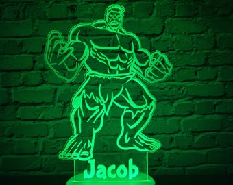 Puede incluir: Luz nocturna verde con la silueta de Hulk y el nombre Jacob debajo.