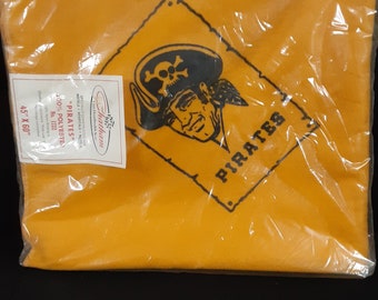 Könnte beinhalten: Eine gelbe Fleece-Decke mit einem schwarzen Piraten-Logo und dem Text "Pirates" auf einem schwarzen Schild. Die Decke ist in Plastik verpackt und hat ein Etikett mit der Aufschrift "Chatham 100% Polyester No. 1722 45" x 60"