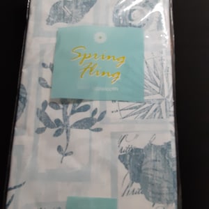 May include: White tablecloth with a blue and white seashell pattern. The tablecloth has the text "Spring Fling" on a turquoise label.