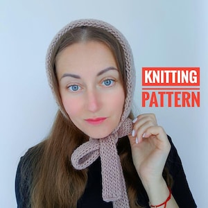 Può includere: Un cappello a maglia con una lunga sciarpa attaccata. Il cappello e la sciarpa sono di colore rosa chiaro. Il testo "KNITTING PATTERN" è in lettere rosse su sfondo bianco.