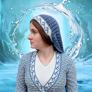 May include: A light blue crochet cardigan and matching head covering with a white and blue patterned trim. The cardigan has a wrap design with a tie closure. The head covering is a hood style with a decorative band.