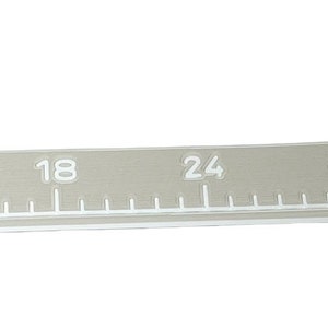 Pu&ograve; includere: Un metro a nastro flessibile di colore grigio con segni e numeri bianchi che vanno da 0 a 122 cm. Il nastro include un piccolo grafico della bandiera degli Stati Uniti vicino al segno dei 114 cm, con tacche bianche per misurazioni precise.
