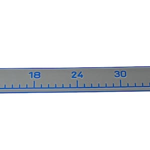 Pu&ograve; includere: Un righello piatto e rettangolare grigio con angoli arrotondati, caratterizzato da segni e numeri blu stampati da 0 a 48 pollici. Il righello ha un bordo blu e una piccola icona della bandiera americana vicino al segno dei 48 pollici.