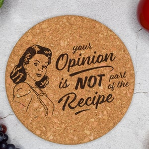 Puede incluir: Un posavasos redondo de corcho con una ilustración vintage de una mujer y el texto "Your Opinion is NOT part of the Recipe".