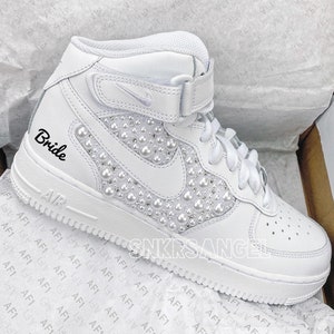 K&ouml;nnte beinhalten: Wei&szlig;e High-Top-Sneaker mit Perlenbesatz und dem Wort "Bride" auf der Seite bestickt.