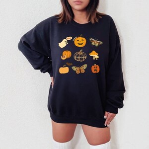 Może przedstawiać: Czarna bluza z nadrukiem o tematyce Halloween z dyniami, duchem, motylem i tekstem "Boo!" i "Little Pumpkins".